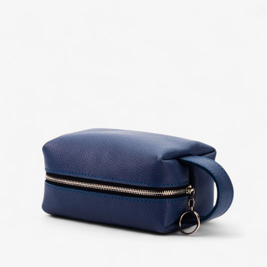 Blue toiletry bag with a gold zipper on a white background