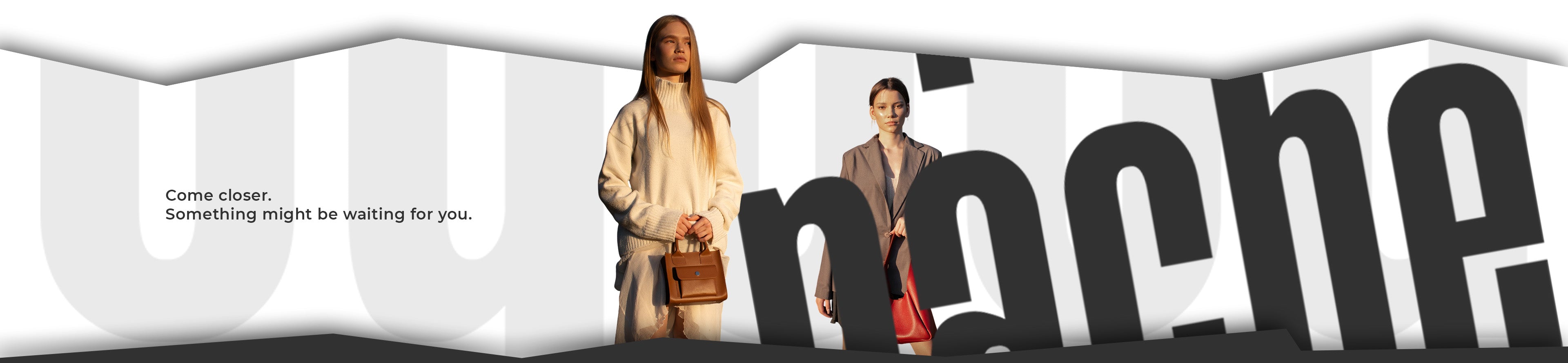 Two women walking with handbags in front of a large Uniche logo.