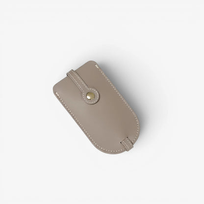 Gray leather pouch with a button on a white background