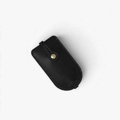 Black leather pouch with a gold button on a white background