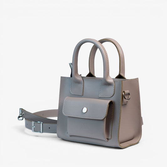 Pache gray smooth leather mini tote bag with front pocket and adjustable strap. Can be carried by hand, shoulder, or crossbody.
